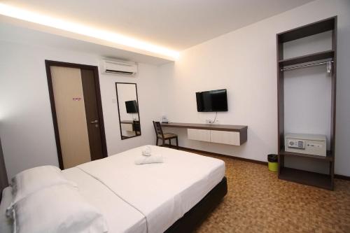 a hotel room with a bed and a television at Pavilion Inn in Miri