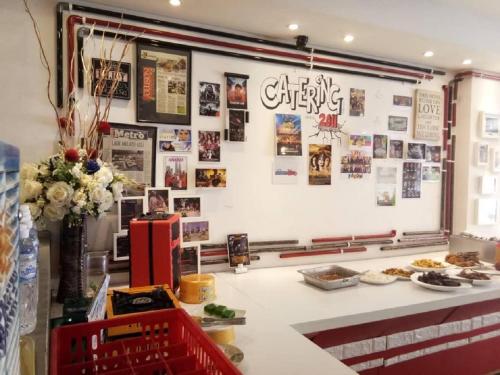 a restaurant with a white counter with pictures on the wall at M Design Hotel @ Pandan Indah in Kuala Lumpur