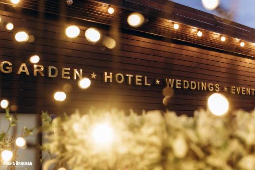 a building with a sign that reads garden hotel and weddings at Garden Hotel Boutique & Events in Haifa