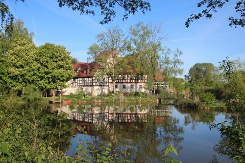 a view of a building from across the water at Gutshof Andres in Kirchlauter