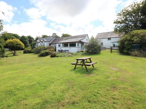 a picnic table in a field in front of a house at Morfa Isaf Cottage in Llangranog