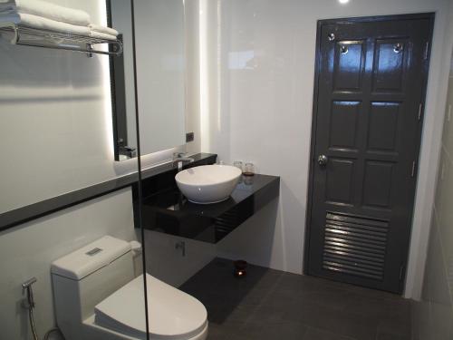 a bathroom with a white toilet and a sink at Laluna Hotel And Resort, Chiang Rai in Chiang Rai