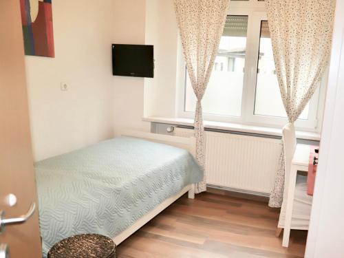 Schlafzimmer mit einem Bett und einem Fenster in der Unterkunft Hotel Aurelia in Frankfurt am Main