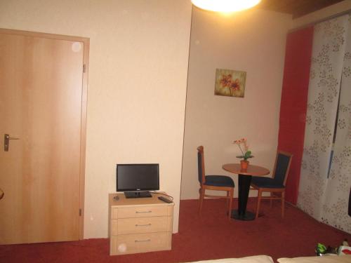 a room with a small table with a television on a dresser at Grüner Baum Nürnberg Brunn in Nuremberg