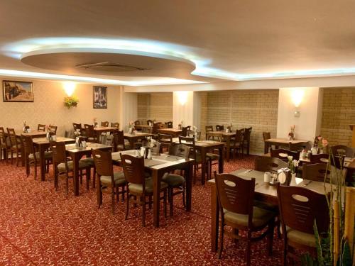 um restaurante com mesas e cadeiras num quarto em Adana Yukselhan Hotel em Adana