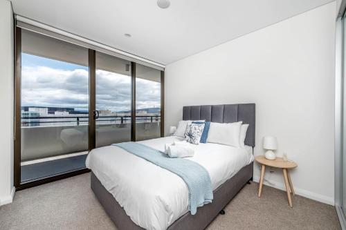 ein Schlafzimmer mit einem großen Bett und einem großen Fenster in der Unterkunft Luxe 2 Bedroom Apartment in Barton in Kingston 