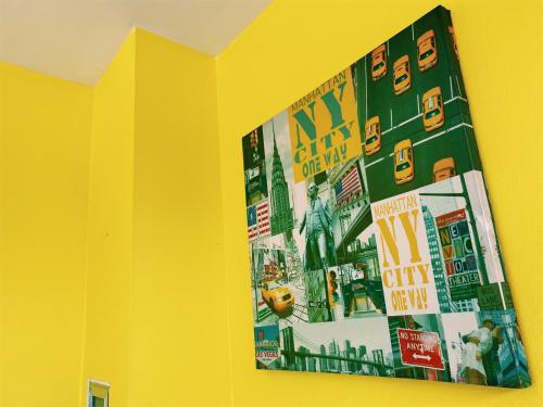 a picture on a yellow wall in a room at Andaman Place in Thalang