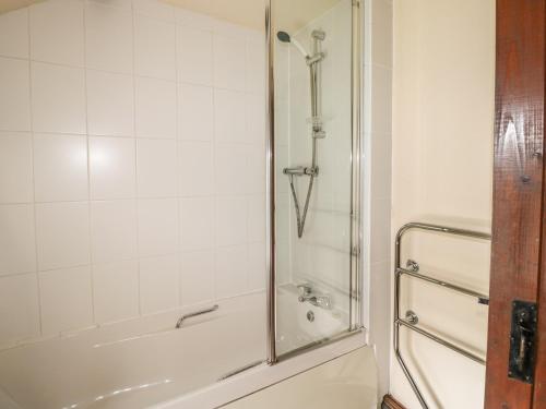 a bathroom with a shower and a bath tub at Mill Cottage in Tintagel