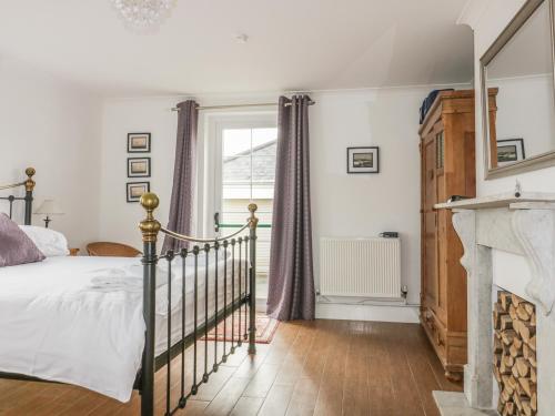 Un dormitorio con una cama y una chimenea. en Apartment 1, Trearren, en St. Agnes