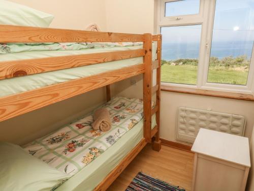 two bunk beds in a room with a window at Kitticarn in Trevilley