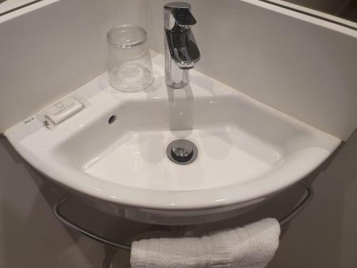 a white sink with a faucet and towels at Hostal BESTPRICE Barcelona Stadium in Barcelona