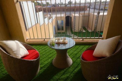 a room with two chairs and a table and a balcony at Masurat Chalet in Riyadh