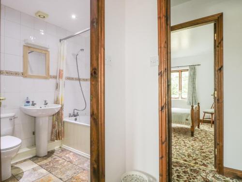 a bathroom with a sink and a tub and a toilet at Springarth Cottage in Morland