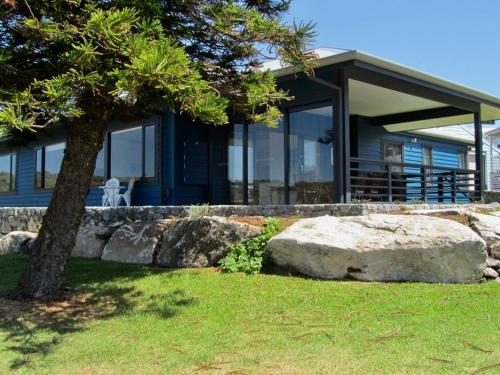 a house with a tree and a rock at Storm Bay Cottage in Augusta