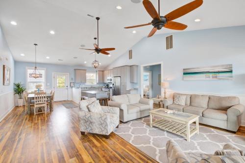 a living room with two couches and a kitchen at LaiDDback in Folly Beach