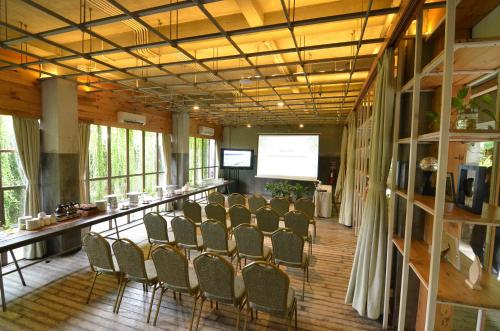 a conference room with chairs and a podium with a screen at Greenhost Boutique Hotel Prawirotaman in Yogyakarta