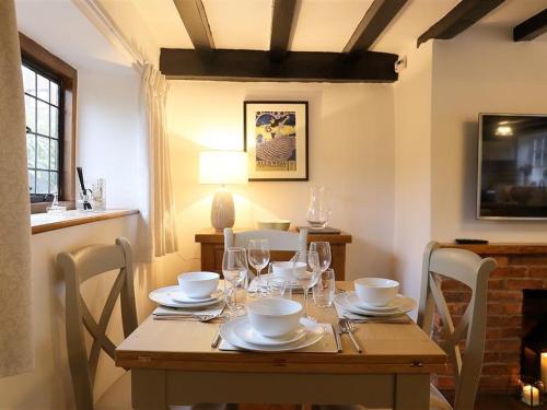 a wooden table with glasses and plates on it at One Masons Court in Stratford-upon-Avon