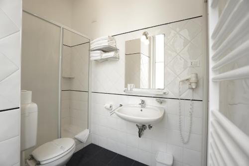 a white bathroom with a sink and a toilet at Nuovo Albergo Centro in Trieste