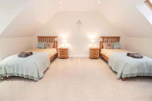 1 dormitorio en el ático con 2 camas y 2 mesitas de noche en Arnant, en Barmouth