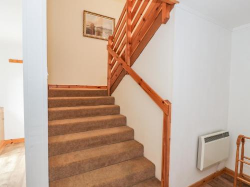 a staircase in a house with wooden railings at The Dairy in Newton Stewart