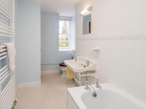 uma casa de banho branca com um lavatório e um WC em Stable Flat em New Scone