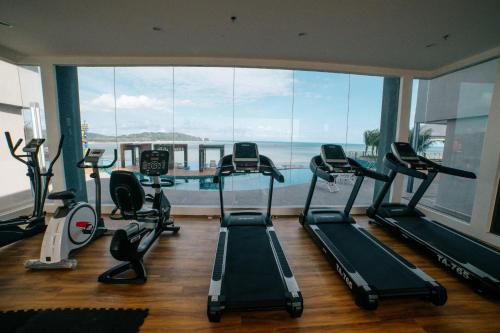 a gym with treadmills and a large window at Swiss-Belhotel Kuantan in Kuantan