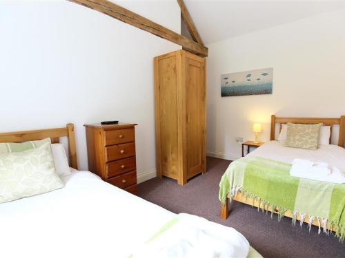 a bedroom with two beds and a dresser and a bed istg at The Old Dairy in Westbury on Severn