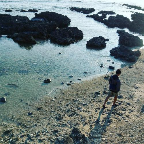 a man standing on a beach near the water at Have FUN villa in Hengchun
