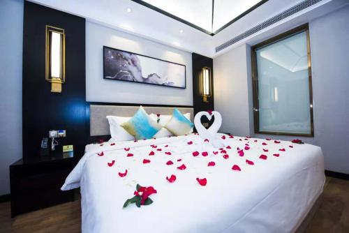 a bedroom with a white bed with red hearts on it at Le Chen Miiya Hotel in Sihanoukville