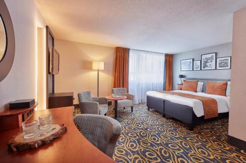 a hotel room with a bed and a desk at Carlton Square Hotel in Haarlem