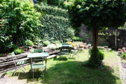 un grupo de mesas y sillas en un jardín en Brunnenhof Randersacker - das kleine Hotel, en Randersacker