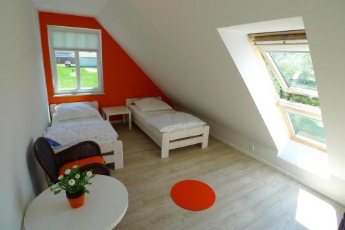 um quarto no sótão com 2 camas e uma mesa em Haus STRANDHAFER WF-07 (rechts) em Wustrow