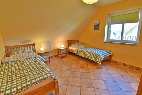2 Betten in einem Zimmer mit Fenster und 2 Tischen in der Unterkunft Haus EMMA WF-03 rechte Haushälfte in Wustrow