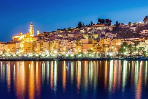 a view of a city lit up at night at EXCEPTIONNEL !!! VENEZ SEJOURNER DANS LES 3 SUITES D'UN AUTHENTIQUE ANCIEN PALACE DE LA "BELLE EPOQUE" de 1874 !!! UNIQUE !!! in Menton