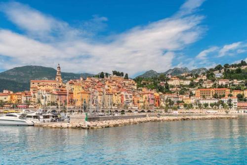 a view of a city from the water at EXCEPTIONNEL !!! VENEZ SEJOURNER DANS LES 3 SUITES D'UN AUTHENTIQUE ANCIEN PALACE DE LA "BELLE EPOQUE" de 1874 !!! UNIQUE !!! in Menton