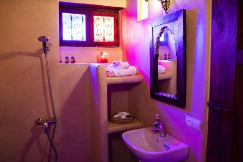 a pink bathroom with a sink and a mirror at Dar Settash in Fès