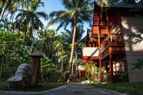 a building with palm trees next to a street at Sea Shell Neil in Neil Island