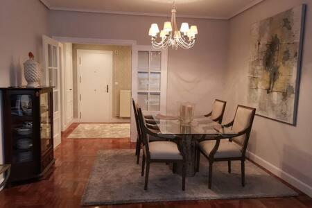 a dining room with a table and chairs and a chandelier at Habitación con baño privado en Bilbao in Bilbao