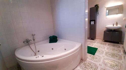 a bathroom with a bath tub and a sink at Ferienwohnung Pasewalk, 110 qm mit Geschirrspüler in Papendorf