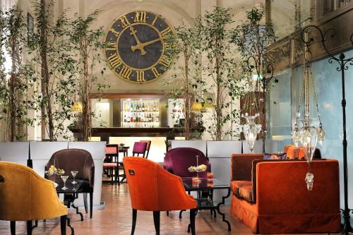 a restaurant with a large clock on the wall at Grand Hotel Continental Siena - Starhotels Collezione in Siena