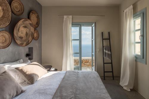 a bedroom with a bed and a view of the ocean at Verina Astra in Artemonas