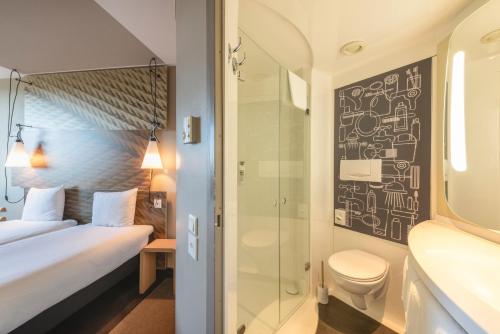 La salle de bains est pourvue d'une douche, d'un lit et de toilettes. dans l'établissement ibis Bern Expo, à Berne