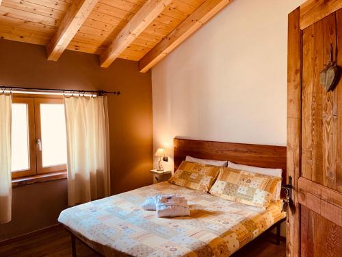 1 dormitorio con 1 cama en una habitación con techos de madera en Mortirolo, en Mazzo di Valtellina