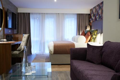 a hotel room with a bed and a couch at Wychwood Park Hotel and Golf Club in Crewe