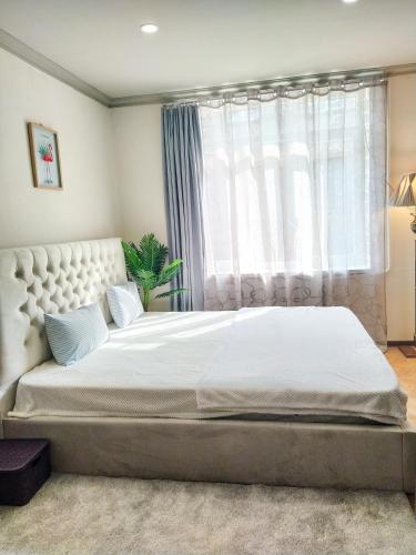 a bedroom with a large white bed with a window at Old Tbilisi Apartments in Tbilisi City
