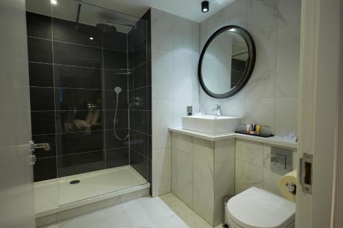a bathroom with a shower and a toilet and a sink at Wychwood Park Hotel and Golf Club in Crewe