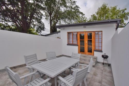 a white patio with a table and chairs at De Witte Huis in Bethlehem