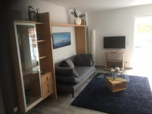 uma sala de estar com um sofá e uma televisão em Ferienwohnung 2, Wildes Wässerchen em Bad Hersfeld