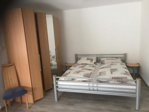 1 dormitorio con 1 cama y 2 armarios de madera en Ferienwohnung 2, Wildes Wässerchen, en Bad Hersfeld