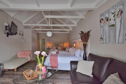 a bedroom with a bed and a couch and a table at De Witte Huis in Bethlehem
